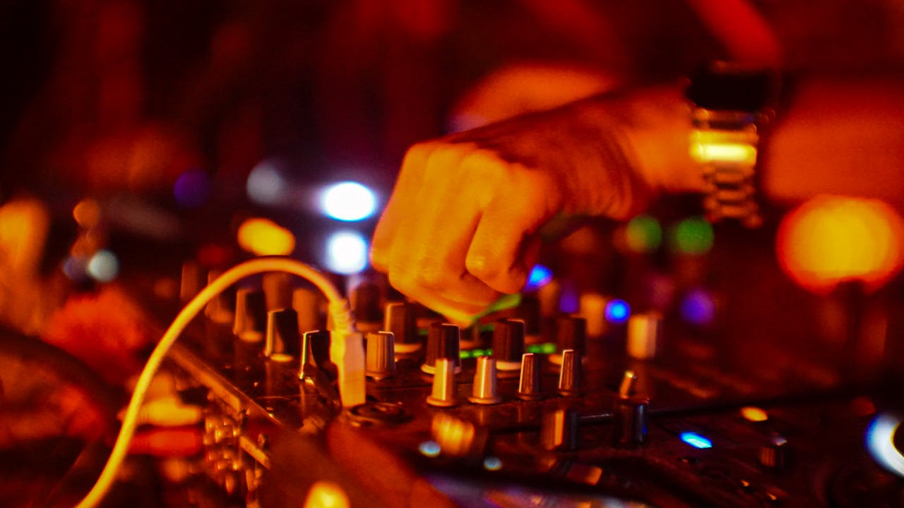 Rhythm of the afterlife Vibrant DJ performance capturing the essence of night parties in Mexico City with dynamic lighting and music equipment.